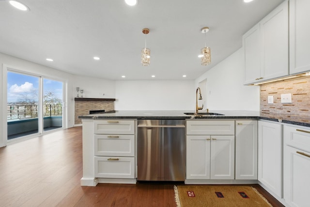 kitchen featuring a sink, decorative backsplash, dark wood-type flooring, white cabinets, and stainless steel dishwasher