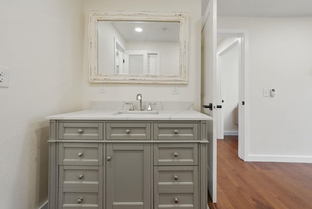 bathroom featuring vanity, baseboards, and wood finished floors