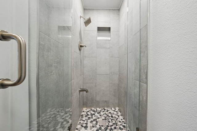 bathroom with a stall shower and a textured wall