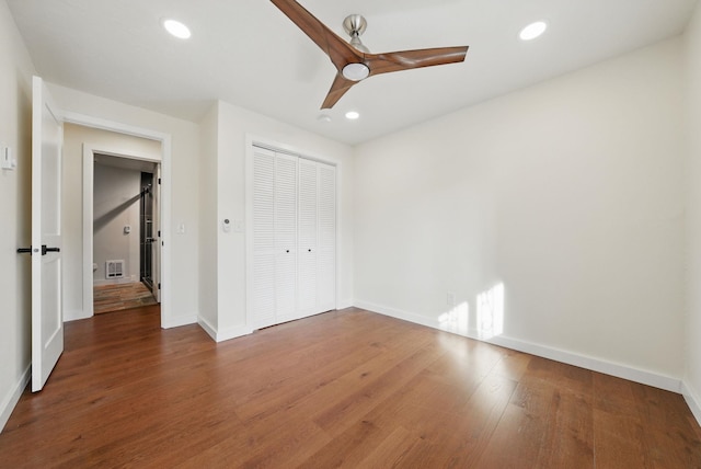 unfurnished bedroom with recessed lighting, wood finished floors, visible vents, and a closet