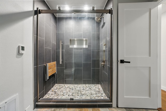 full bathroom featuring visible vents and a shower stall