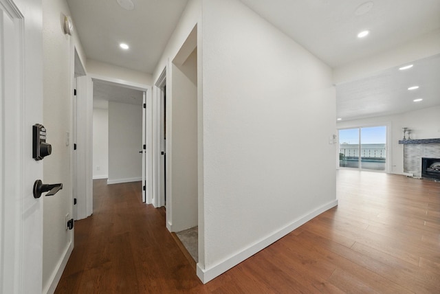 corridor with recessed lighting, wood finished floors, and baseboards