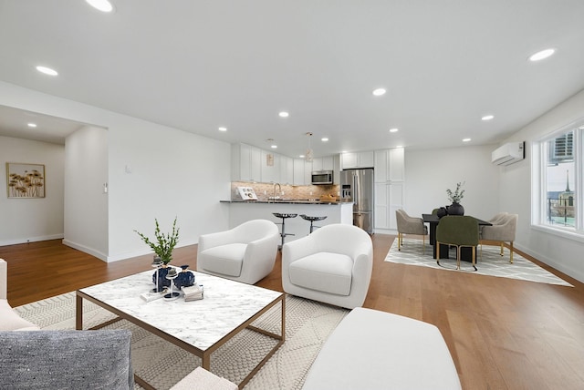 living room with light wood finished floors and recessed lighting