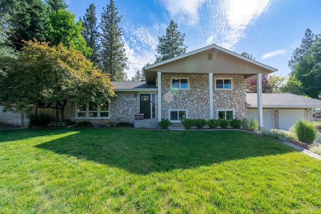 split level home with a garage, a front lawn, and fence