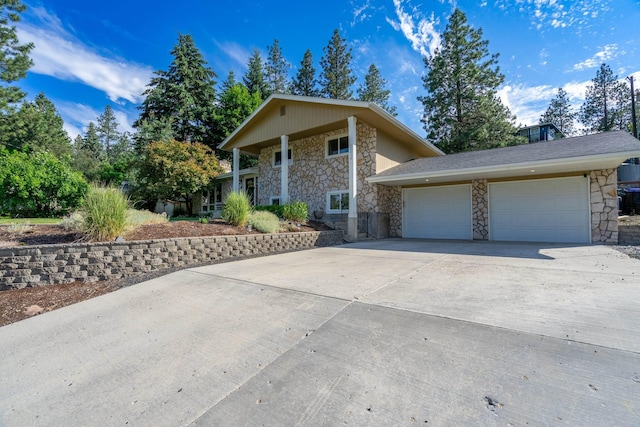 view of front facade featuring stone siding, a garage, and driveway