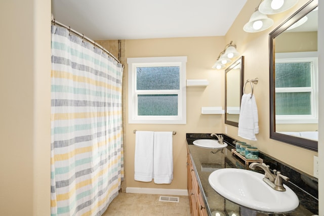 full bathroom with double vanity, visible vents, baseboards, and a sink