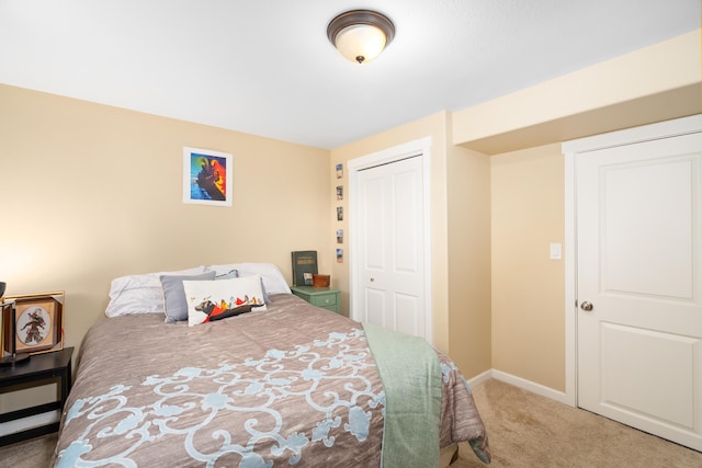 carpeted bedroom with a closet and baseboards