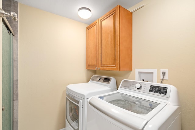 clothes washing area featuring cabinet space and independent washer and dryer