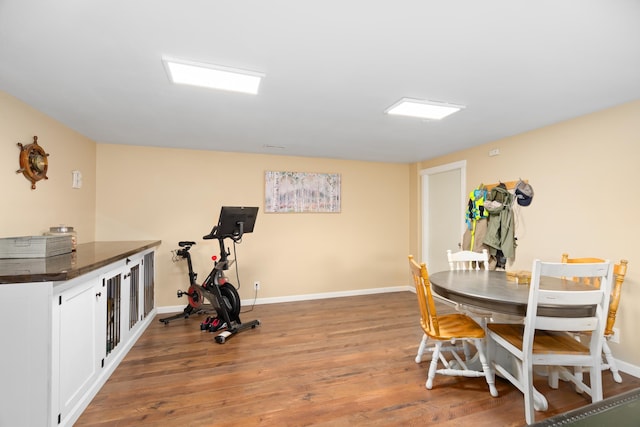 workout room featuring baseboards and wood finished floors