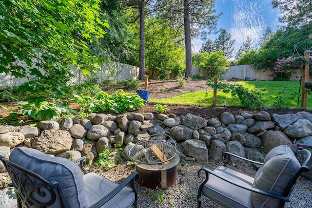 view of yard with a fenced backyard and an outdoor fire pit