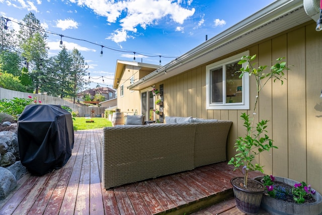 wooden terrace with grilling area, an outdoor hangout area, and fence