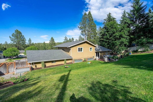 rear view of property with a patio, fence, a lawn, and roof with shingles