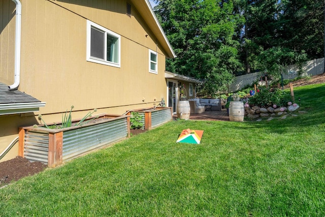 view of yard featuring a vegetable garden, fence, and an outdoor hangout area