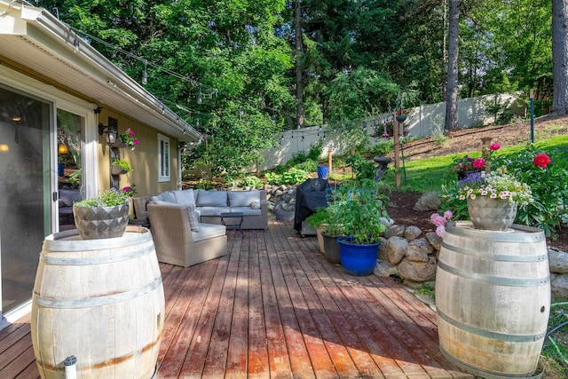 wooden deck featuring an outdoor living space and a fenced backyard