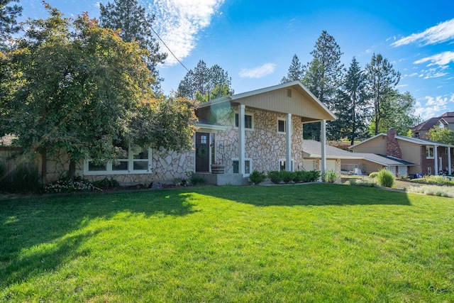 view of front facade featuring stone siding, a garage, and a front yard