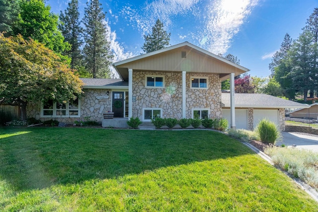 view of front of home featuring stone siding, driveway, a front lawn, and an attached garage