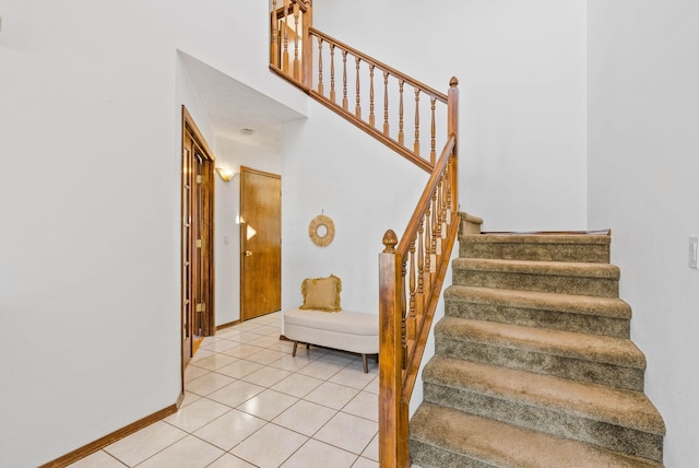 stairs featuring tile patterned floors and baseboards