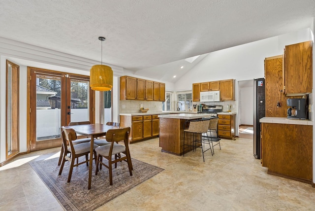 dining space featuring french doors, a textured ceiling, and vaulted ceiling