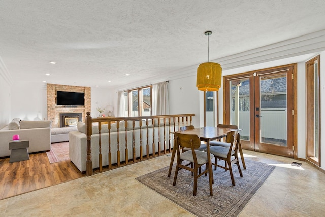 dining area with visible vents, a brick fireplace, recessed lighting, french doors, and a textured ceiling