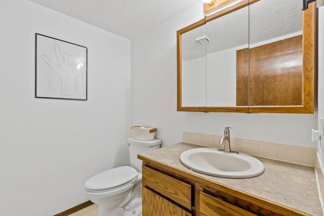 bathroom with a textured ceiling, toilet, and vanity