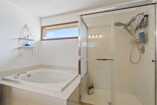 bathroom with a textured ceiling, a bath, and a shower stall