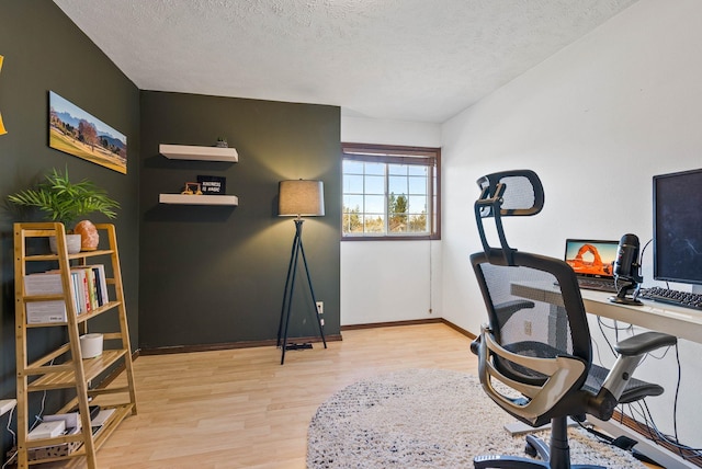 office space with a textured ceiling, baseboards, and wood finished floors