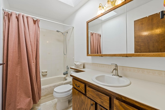 bathroom featuring toilet, a skylight, shower / tub combo, tile patterned floors, and vanity