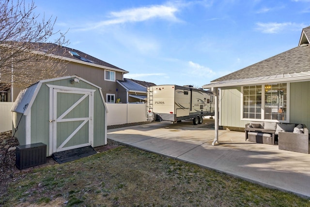 view of yard with a storage unit, central air condition unit, fence, an outdoor structure, and a patio area