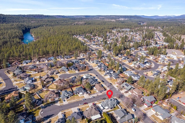 aerial view featuring a mountain view, a view of trees, and a residential view