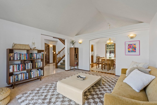 living room featuring tile patterned flooring, stairway, lofted ceiling, carpet floors, and an inviting chandelier