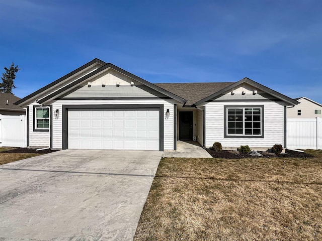 ranch-style home with concrete driveway, an attached garage, fence, and a front lawn