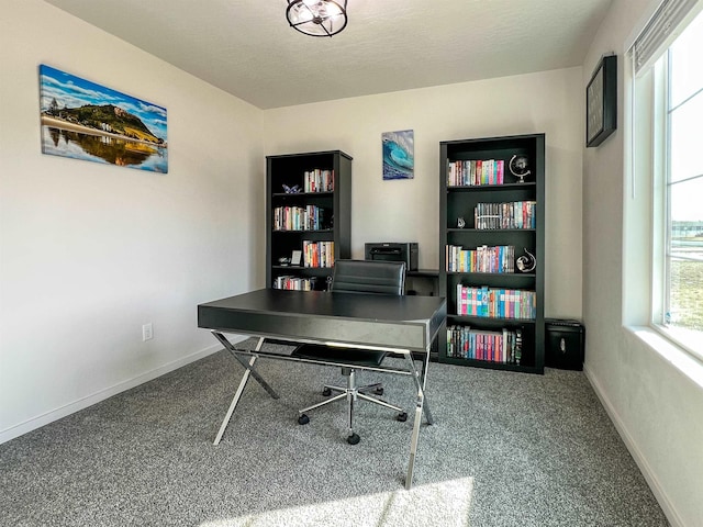 carpeted office with baseboards and a textured ceiling