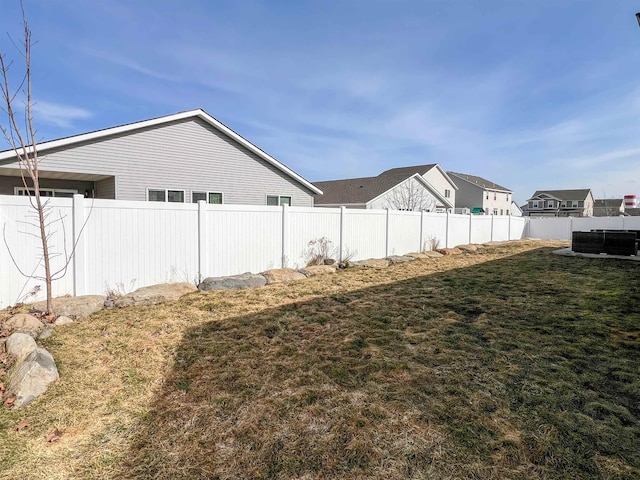 view of yard with central air condition unit and a fenced backyard