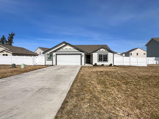 view of front facade with a front lawn, fence, a residential view, concrete driveway, and a garage