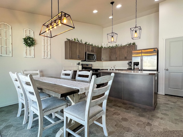 dining area featuring recessed lighting, a high ceiling, and baseboards