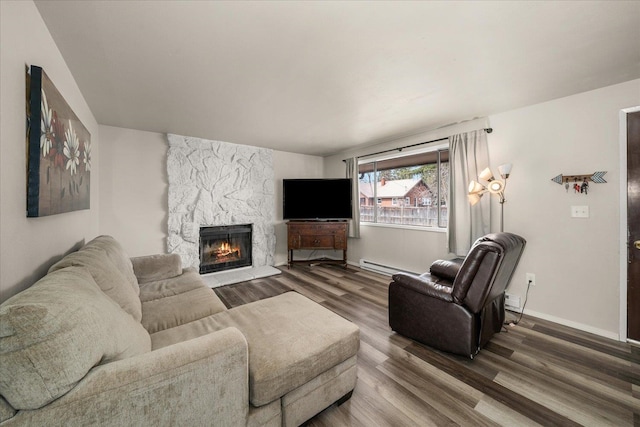 living room with baseboards, baseboard heating, wood finished floors, and a fireplace