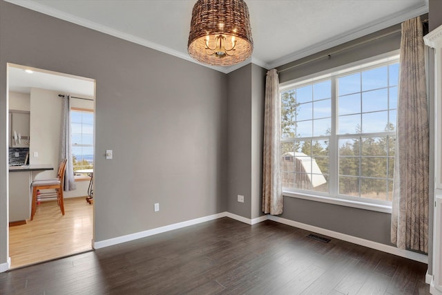 empty room featuring plenty of natural light, visible vents, and ornamental molding