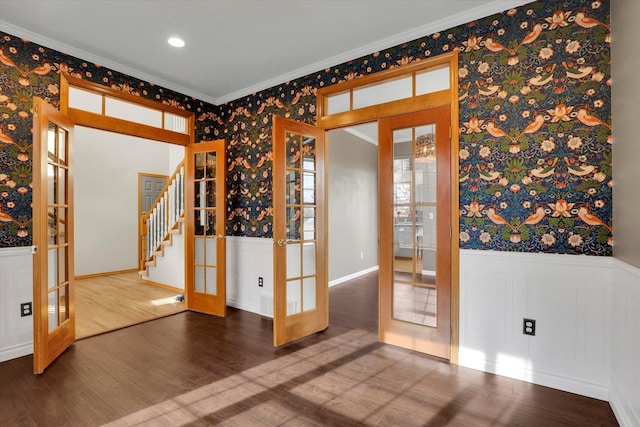 empty room with french doors, a wainscoted wall, and wallpapered walls