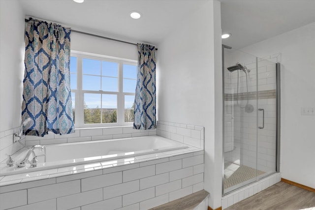 full bathroom with wood finished floors, a garden tub, and a stall shower