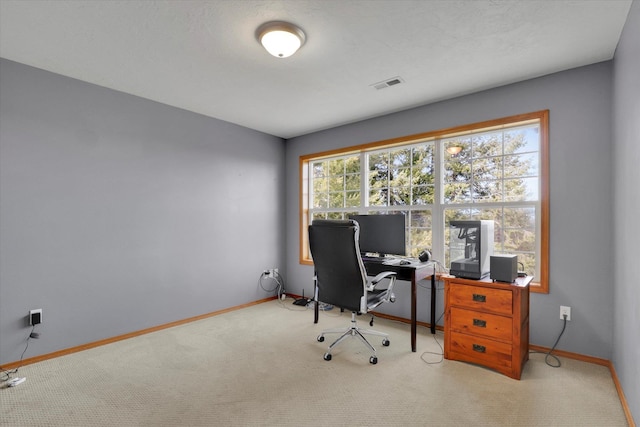 carpeted office space featuring visible vents and baseboards