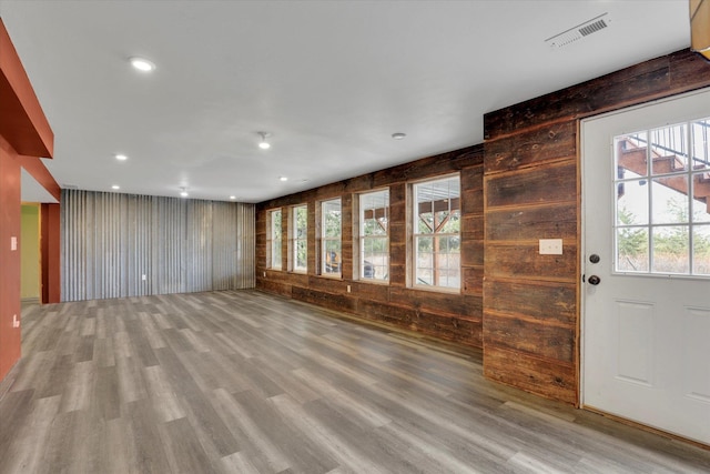 entrance foyer with light wood-style flooring, recessed lighting, visible vents, and wood walls