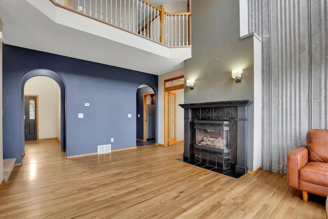 living room with visible vents, wood finished floors, and arched walkways