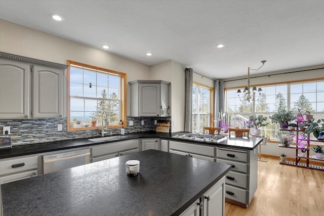 kitchen with decorative backsplash, dark countertops, appliances with stainless steel finishes, and a sink