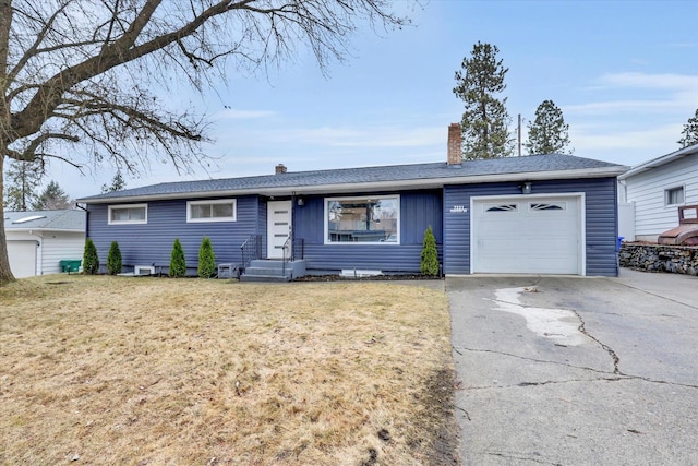 ranch-style home with an attached garage, a chimney, driveway, and a front lawn