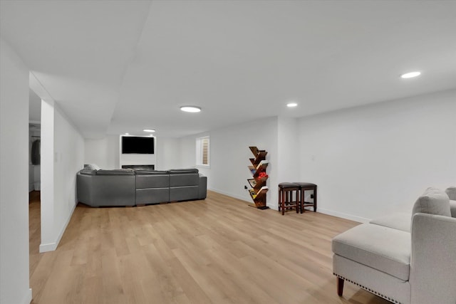 living area featuring recessed lighting, baseboards, and light wood-style floors