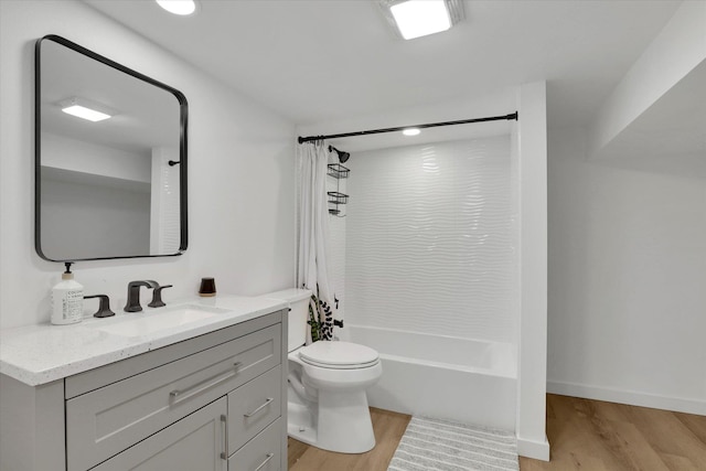 full bath featuring baseboards, toilet, wood finished floors, shower / bath combination with curtain, and vanity