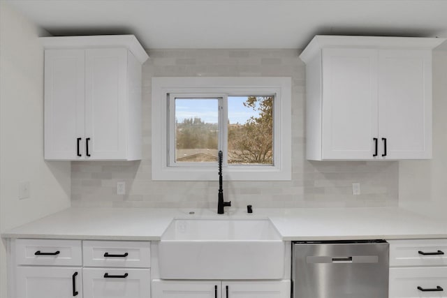 kitchen featuring white cabinetry, a sink, light countertops, stainless steel dishwasher, and tasteful backsplash