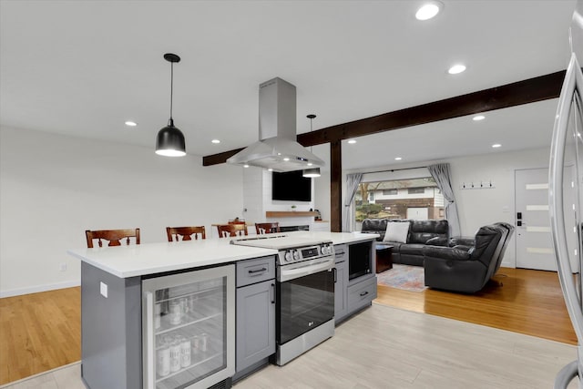 kitchen featuring island exhaust hood, beverage cooler, open floor plan, and appliances with stainless steel finishes