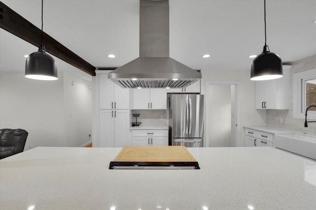 kitchen featuring island exhaust hood, decorative backsplash, a sink, and freestanding refrigerator