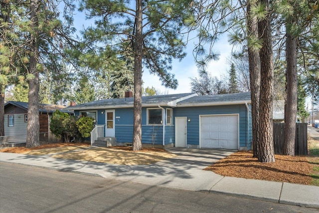 ranch-style house with concrete driveway, an attached garage, and a chimney